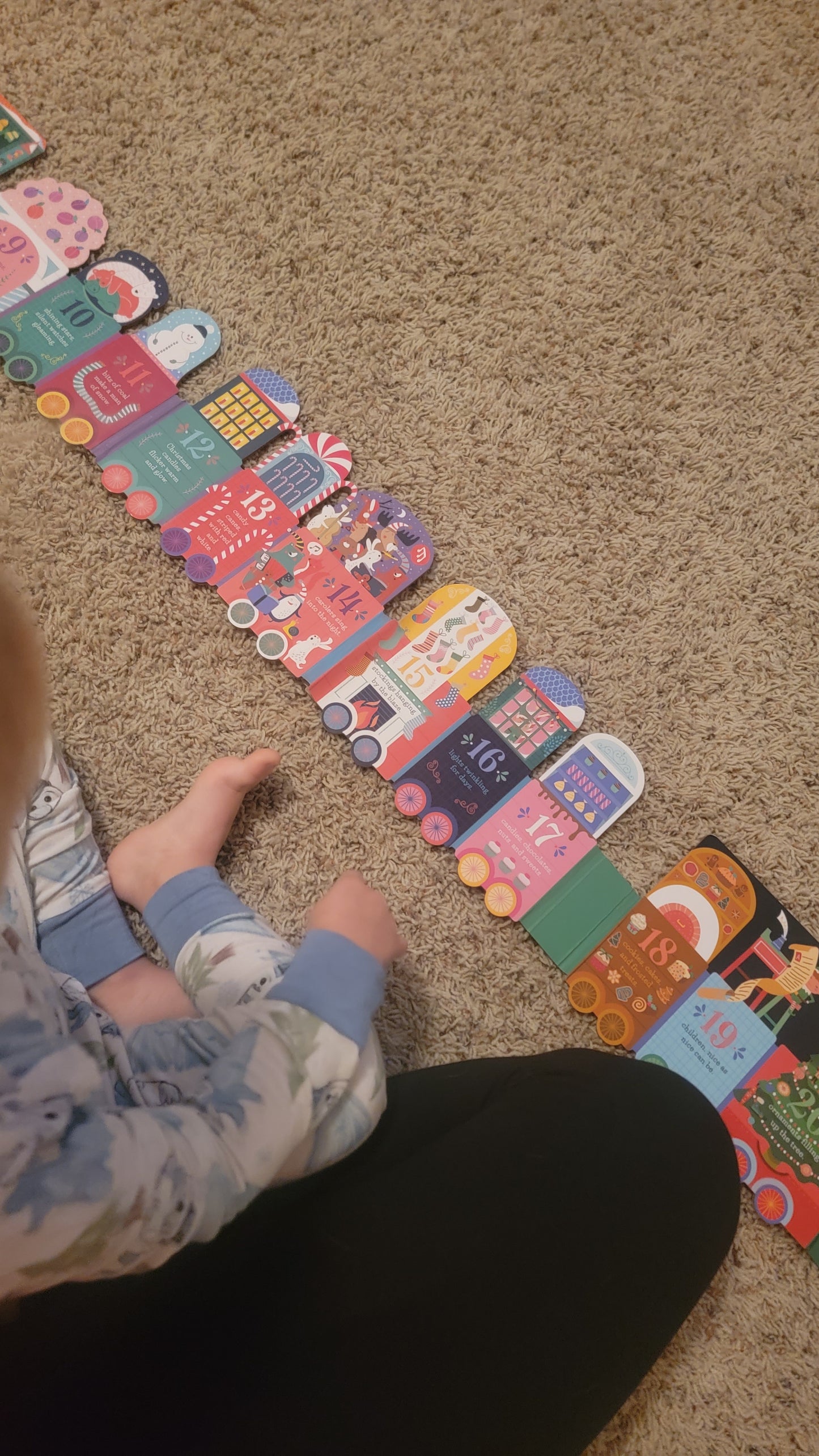 Toddler reading All Aboard the Christmas Train, enjoying interactive counting, seek-and-find activities, and festive Christmas illustrations