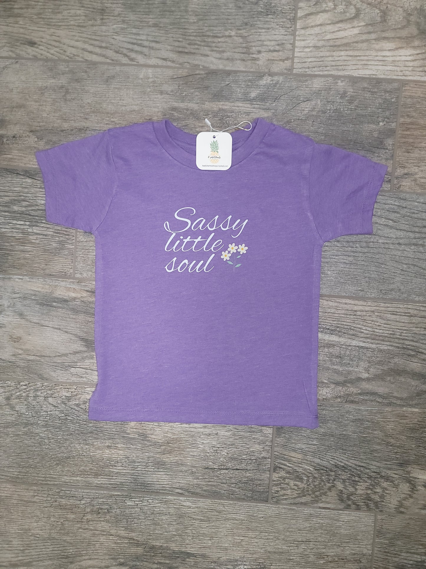 Flat lay of purple Sassy Little Soul Tee, fun and sassy graphic shirt for infants and toddlers