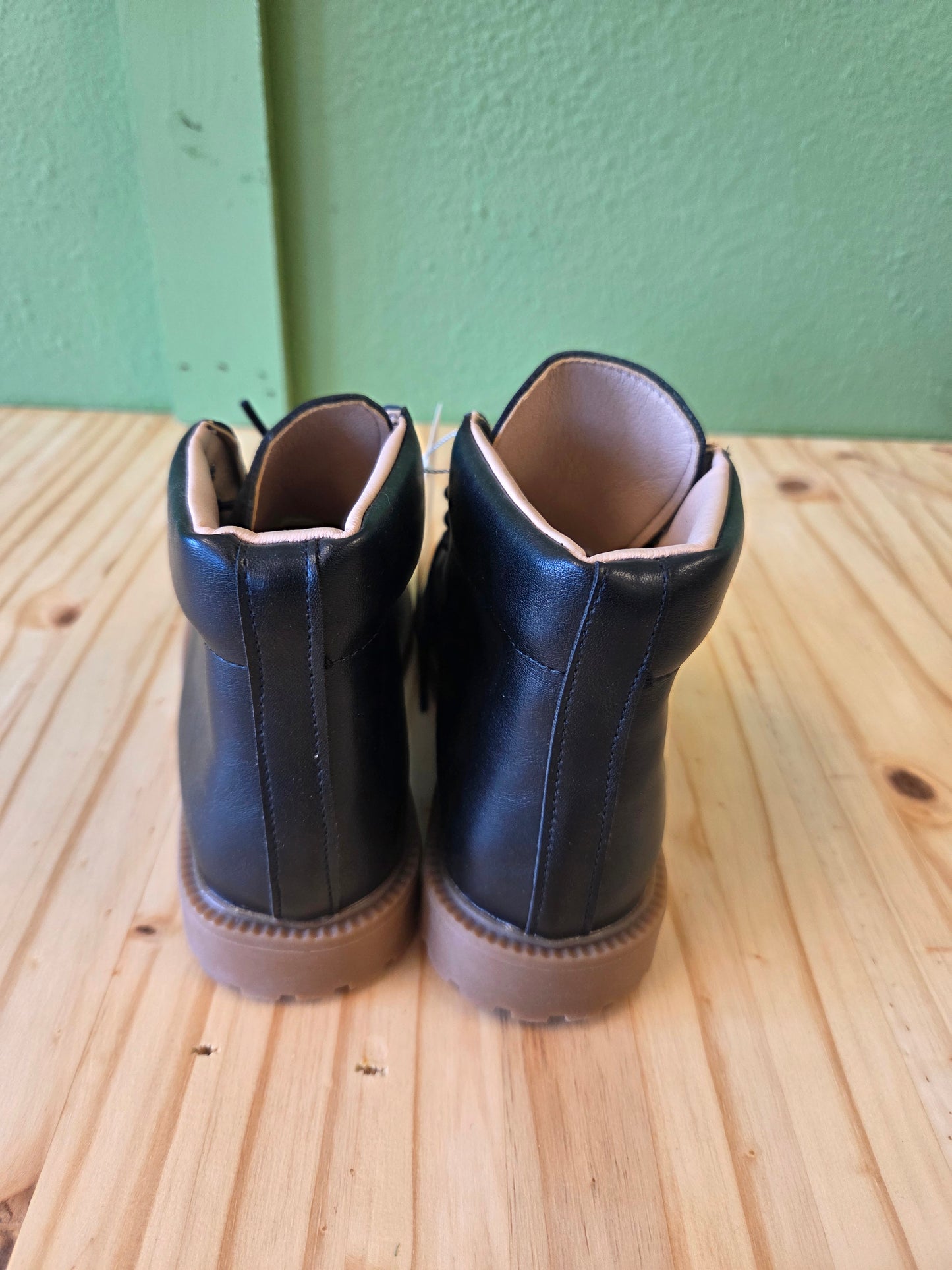 Back view of black unisex toddler and youth combat boots, showing heel and stitching details