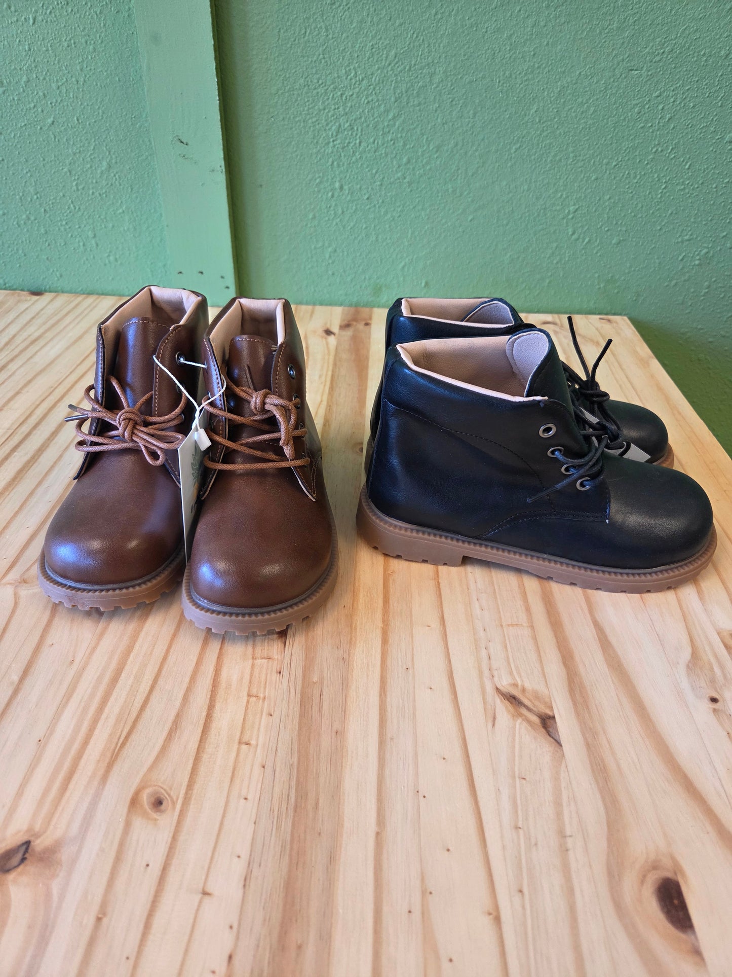 Unisex toddler and youth combat boots in black and brown, displayed together, showing both color options