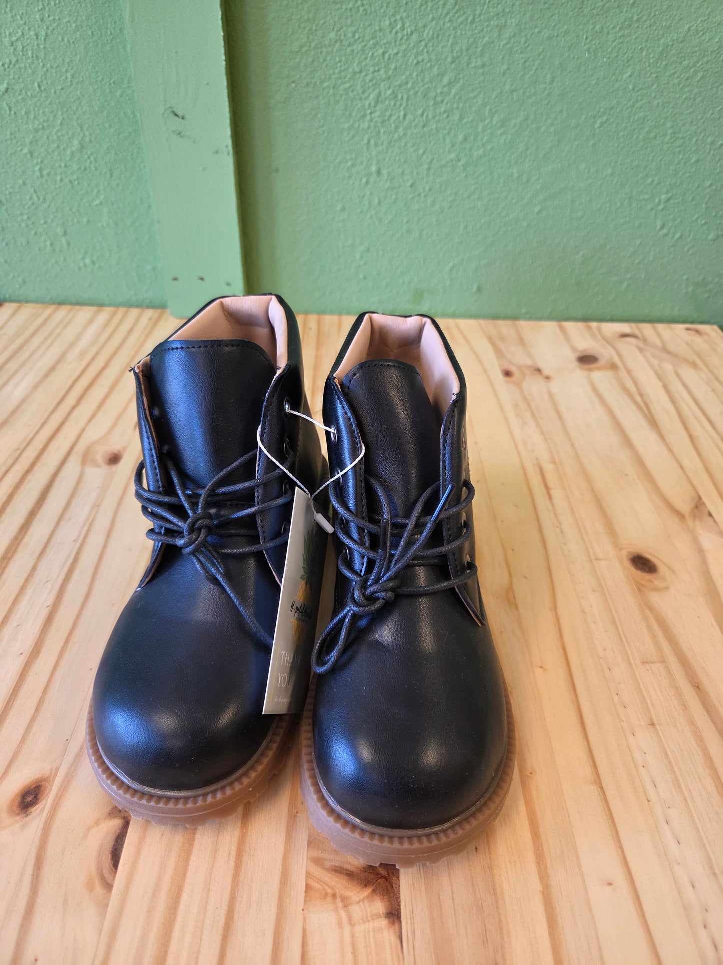 Front view of black unisex toddler and youth combat boots, lace-up style and durable sole