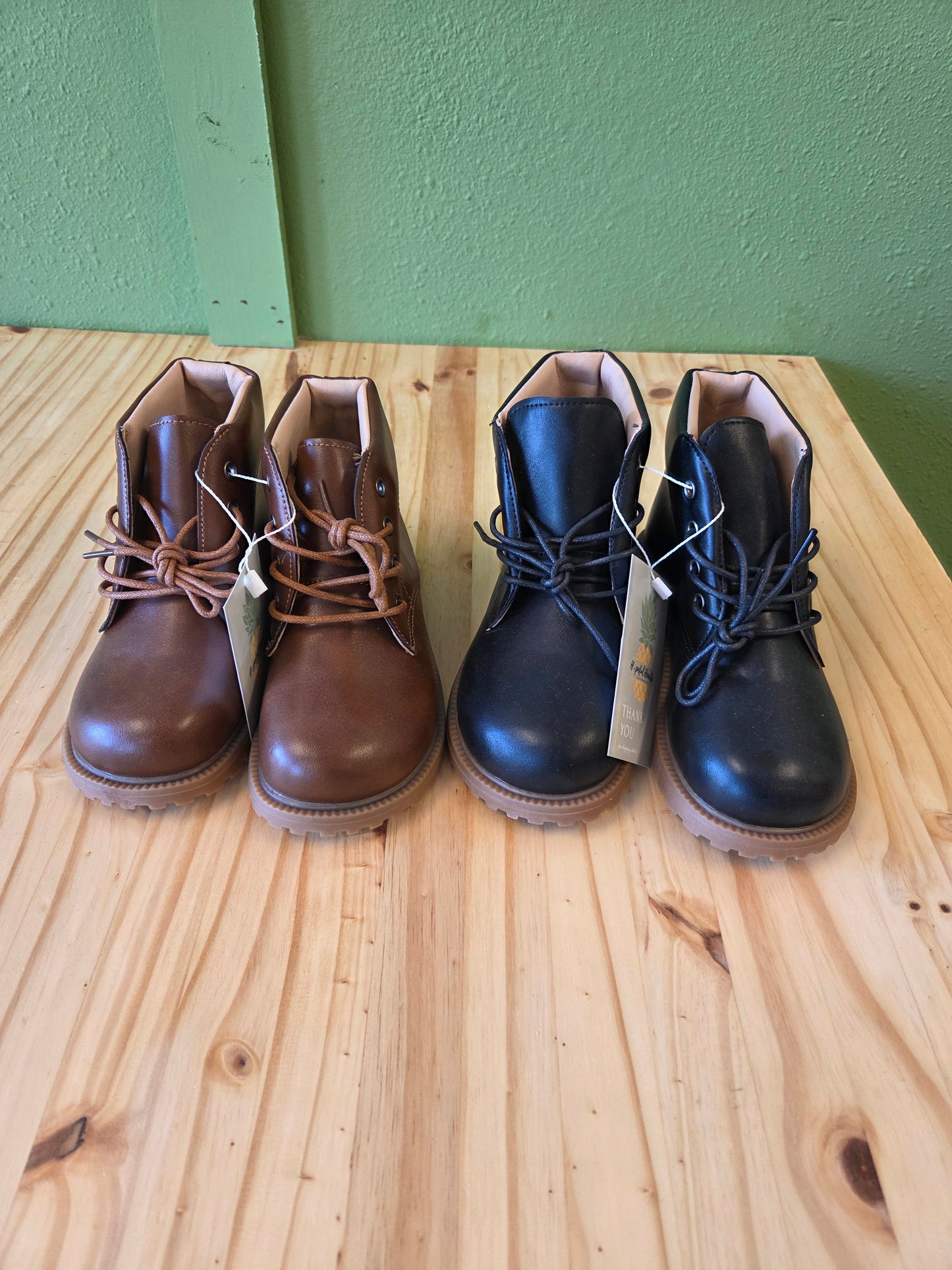 Unisex toddler and youth combat boots in black and brown, front view, stylish lace-up design