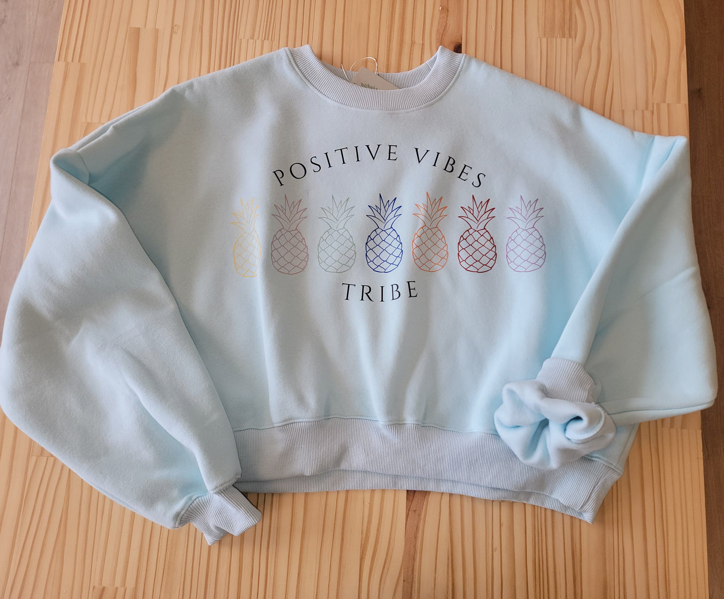 Cozy oversized crop sweatshirt for women, infertility awareness hoodie with Positive Vibes Tribe graphic flat lay