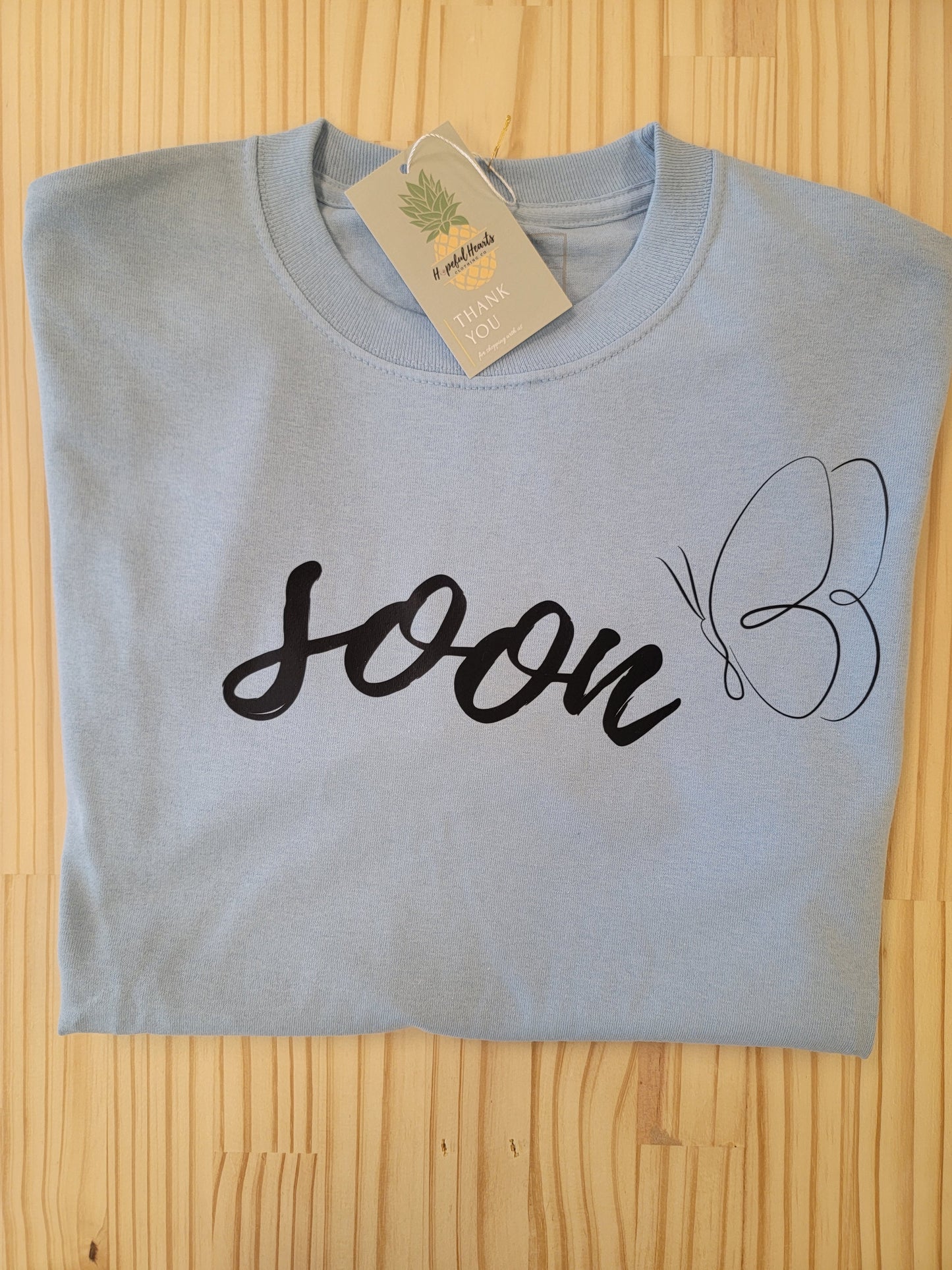 Woman's ‘Soon’ butterfly t-shirt supporting infertility and mental health awareness”
