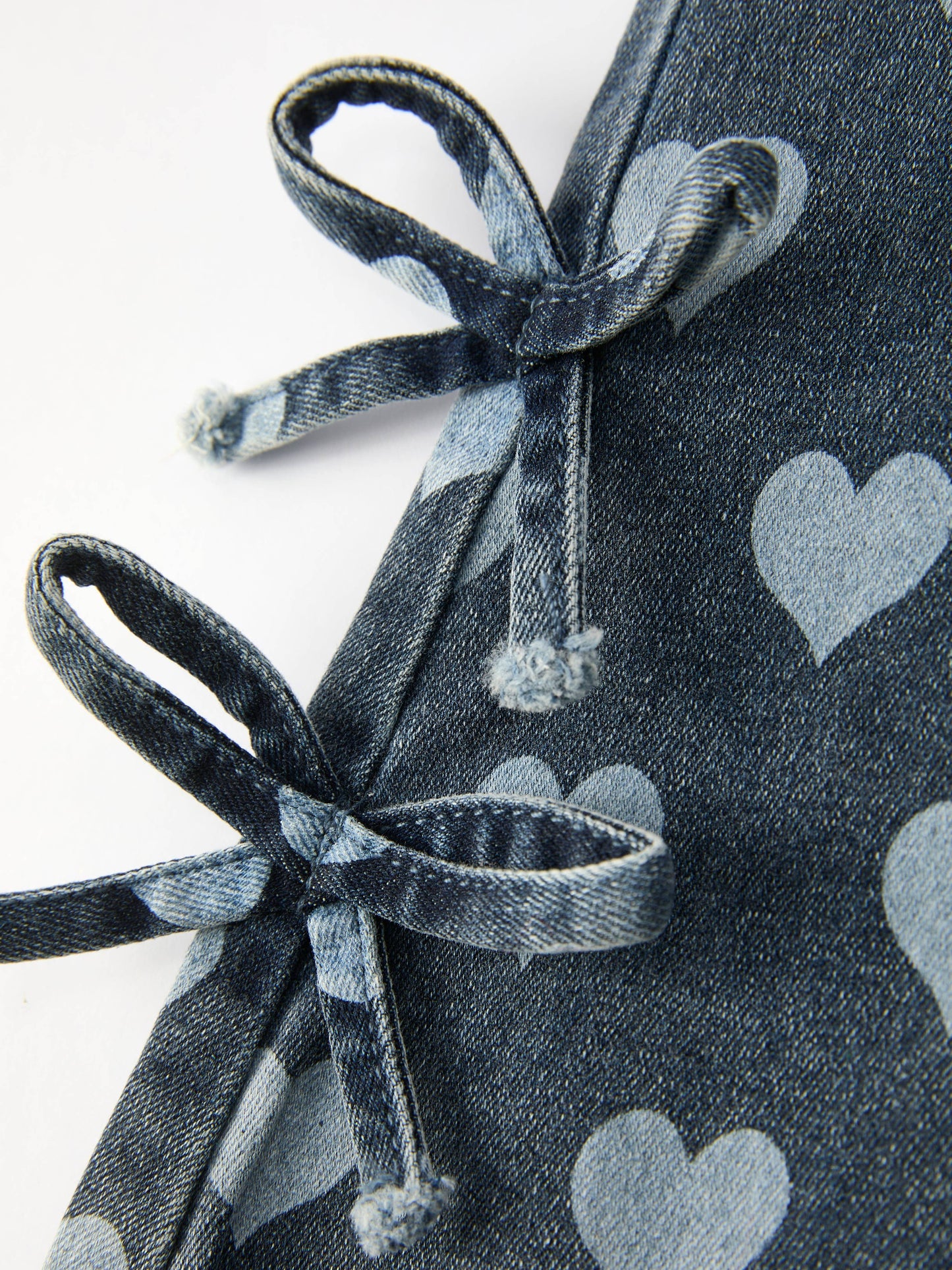 Close-up of bow side tie detail on toddler heart bell bottom pants