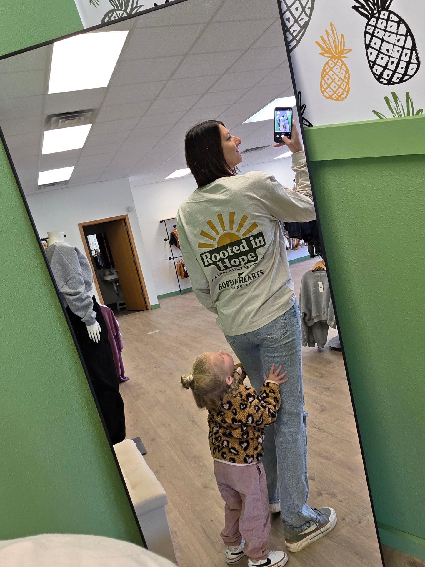 Woman wearing Hopeful Hearts unisex long sleeve tee, back view displaying “Rooted in Hope for Every Journey and Every Heart” quote