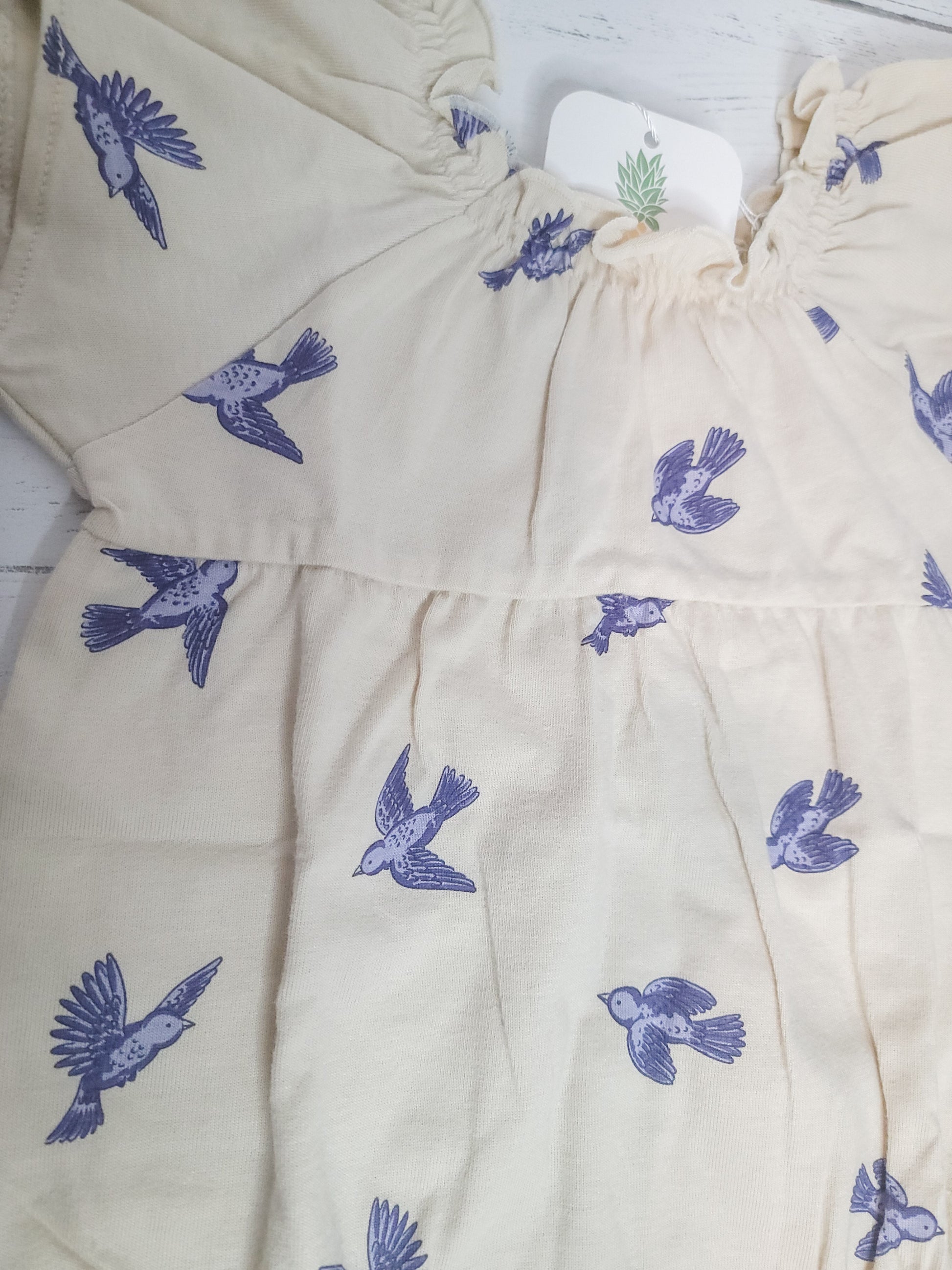 Close-up flat lay of Bluebird Flutter Sleeve Romper, highlighting flutter sleeve detail and cotton texture