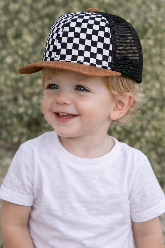 Toddler aged 12 to 24 months wearing a black and white checkerboard trucker hat with a brown brim, shown on a young child for kids accessory styling.