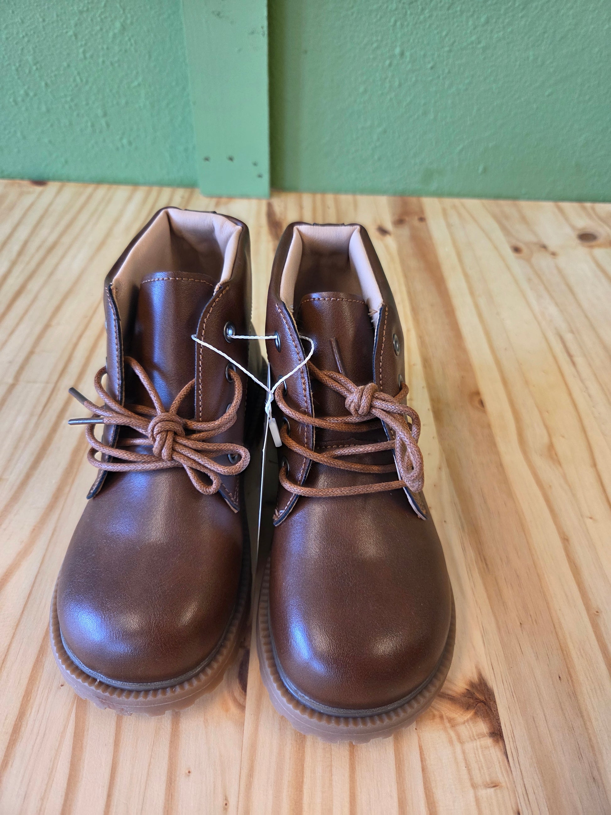 Front view of brown unisex toddler and youth combat boots, lace-up design and durable sole