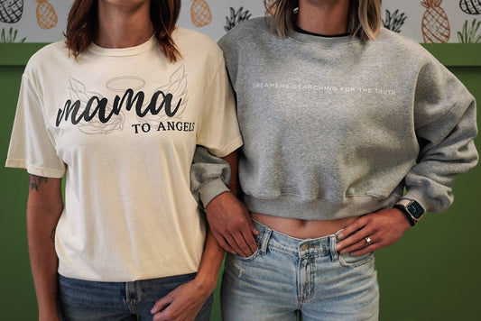 Closer view of two women wearing Dreamers Searching for the Truth oversized crop crewneck and mama to angels tshirt, highlighting fit and style”