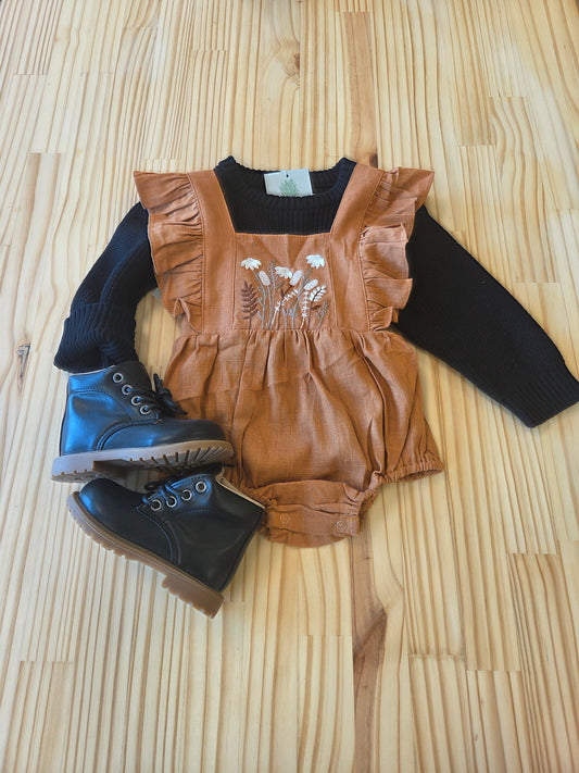 Eleanor Embroidered Romper styled with sweater and boots, full outfit view, showing caramel linen, floral embroidery, and ruffles