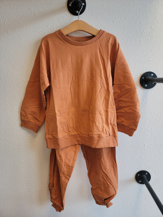 Front view of kids burnt orange sweat set hanging – matching sweatshirt and pants activewear outfit, size 8