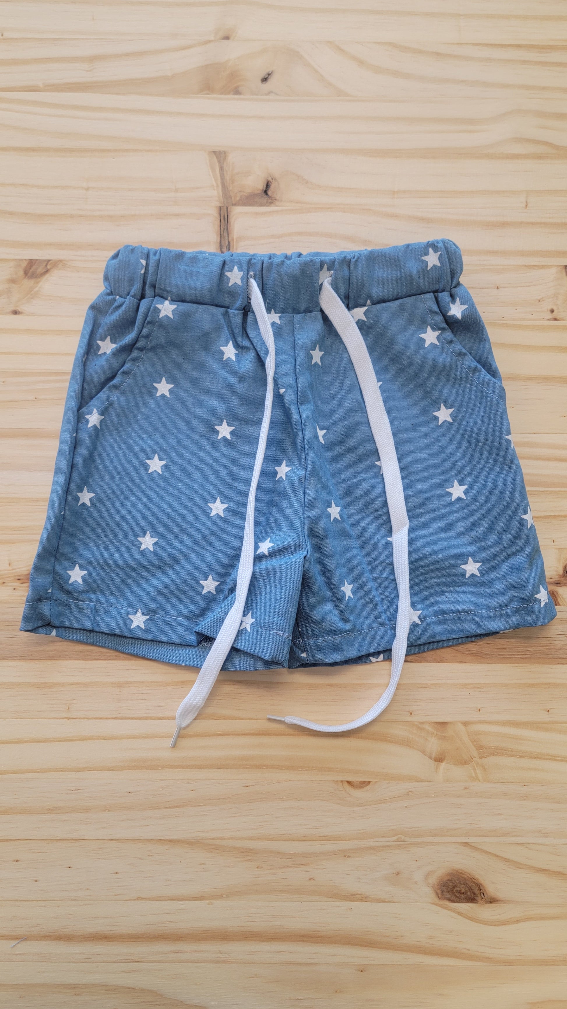 Flat lay of kids’ patriotic star shorts – lightweight red, white, and blue summer shorts for 4th of July