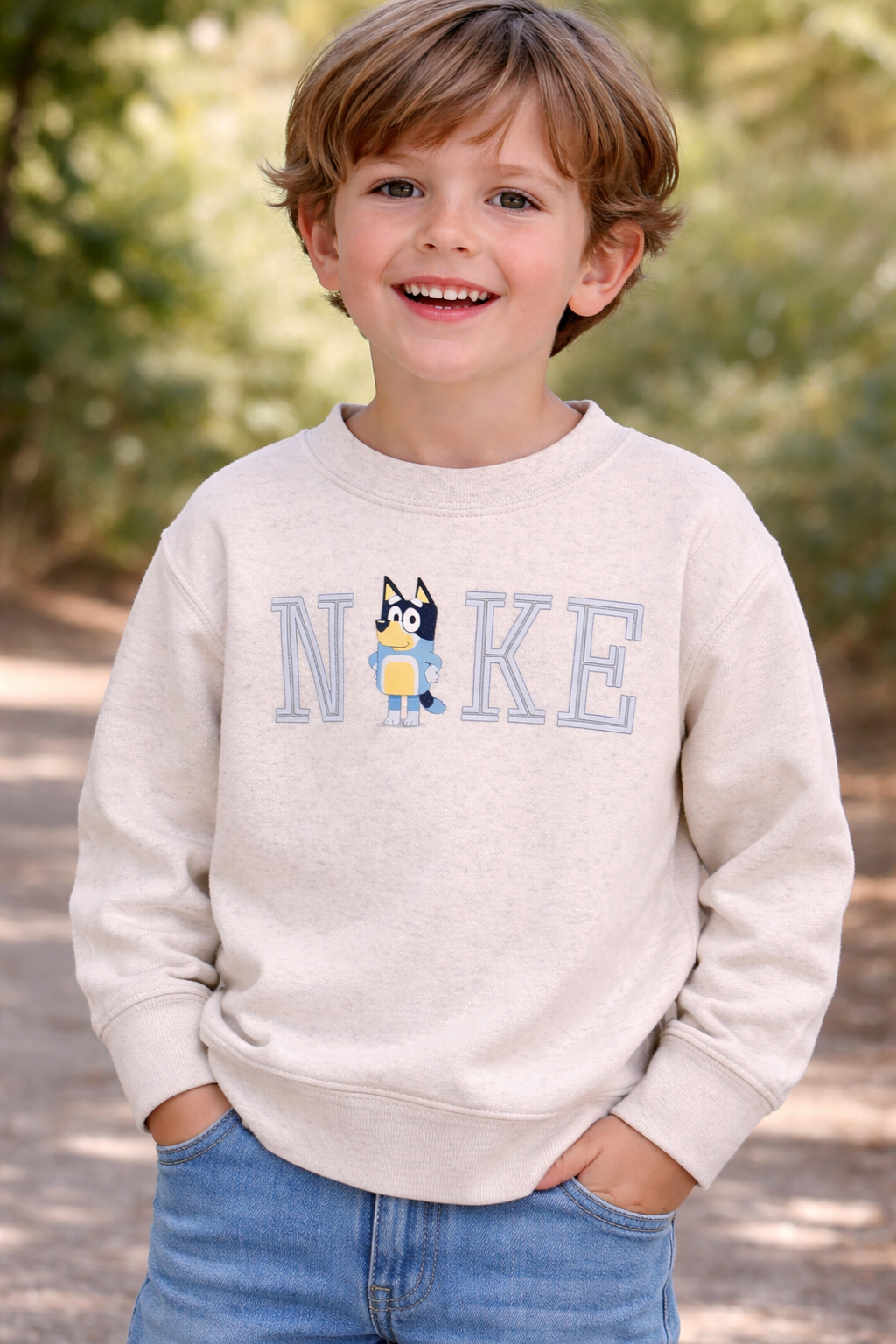 Toddler boy wearing a light heather NKE sweatshirt with Bluey graphic, shown on a 4 year old child model