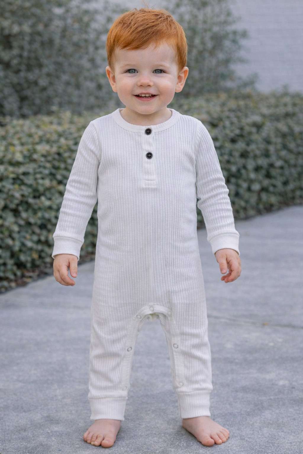 Red-haired infant boy wearing a white ribbed long-sleeve romper, shown on an 18–24 month model with a comfortable fitted silhouette