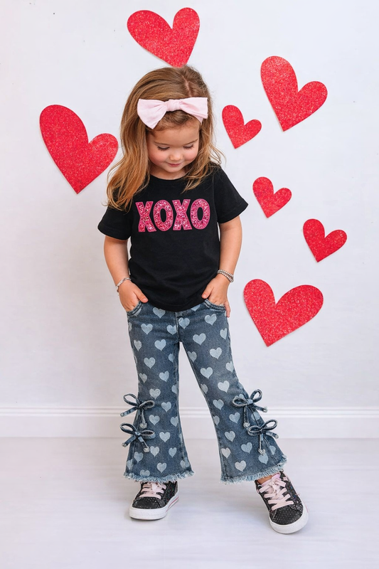 Toddler girl wearing heart print bell bottom pants with bow side ties and elastic waistband
