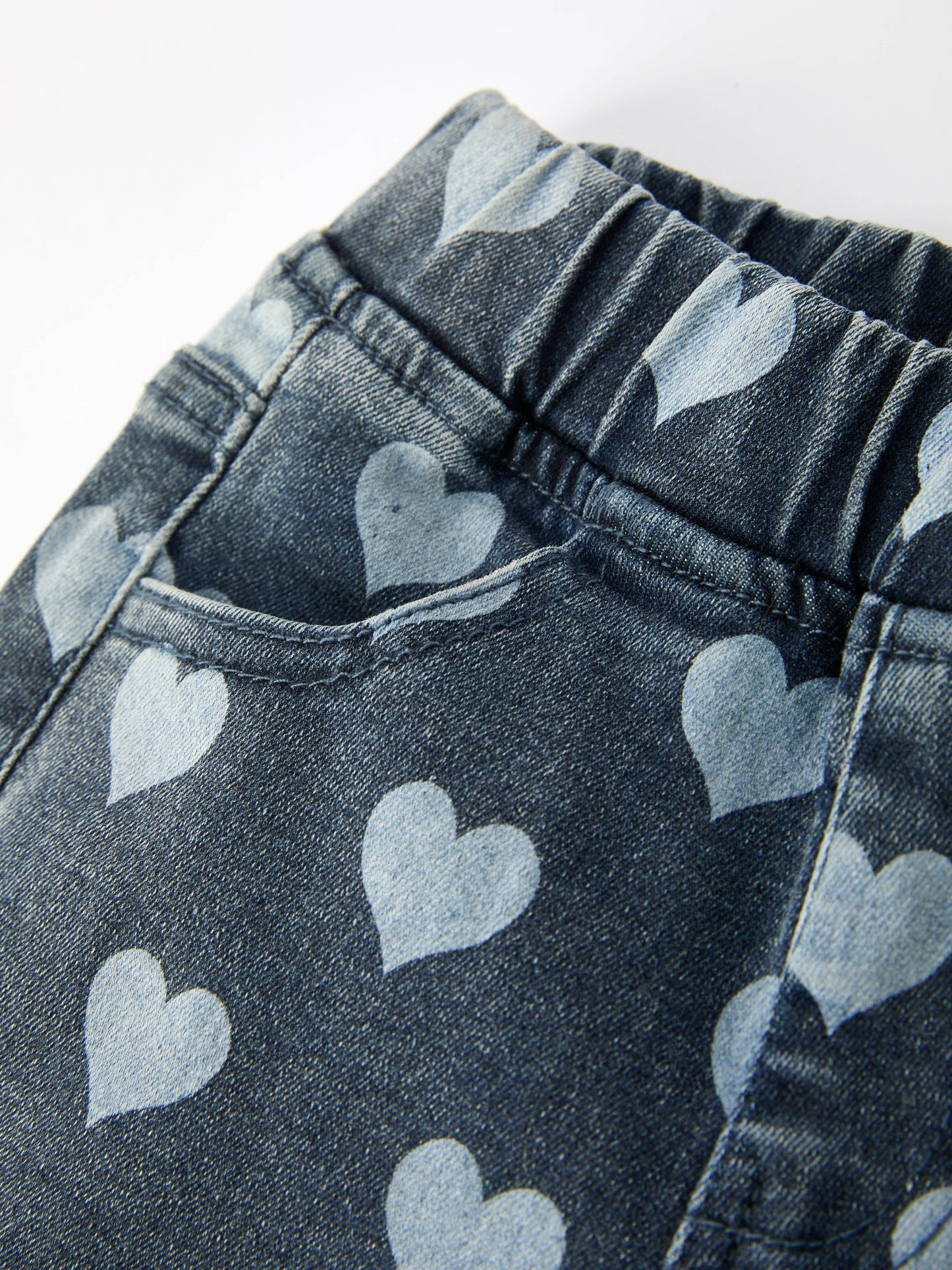 Close-up detail of heart pattern fabric on toddler bell bottom pants