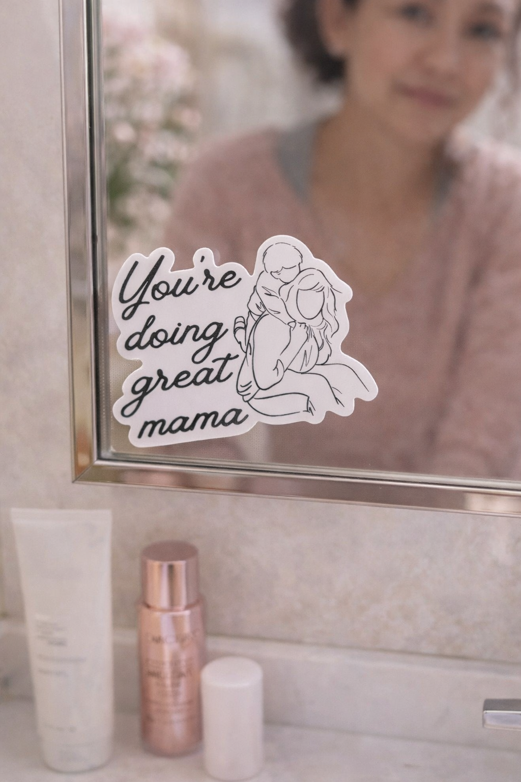 You’re Doing Great Mama vinyl sticker displayed on a bathroom mirror, featuring a minimalist mother and child illustration as an encouraging daily reminder for moms.